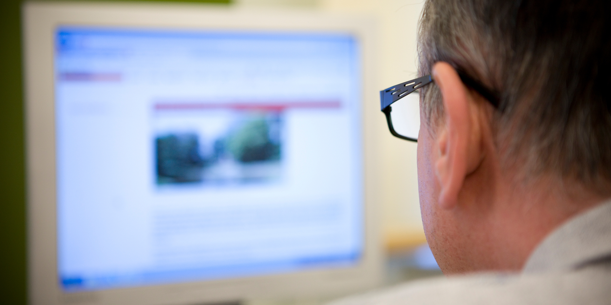 Man kijkt naar computerscherm Man kijkt naar computerscherm